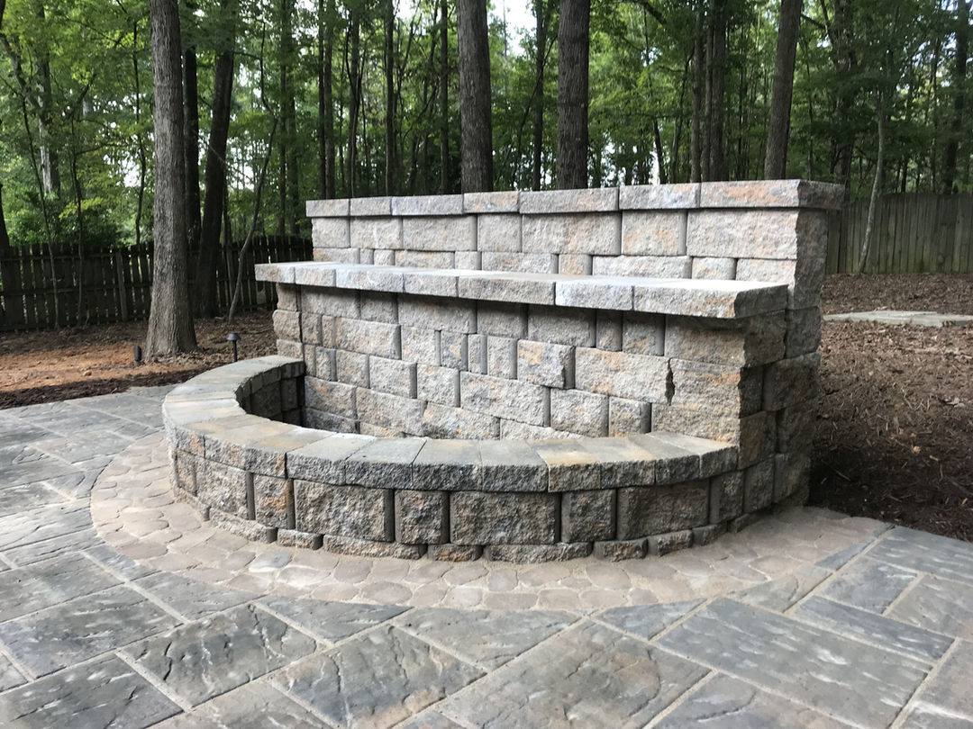 Handcrafted stone outdoor fire pit with tiered seating.