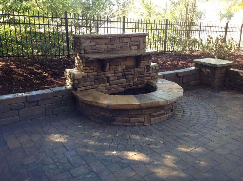 Handcrafted stone outdoor fire pit on a paved patio