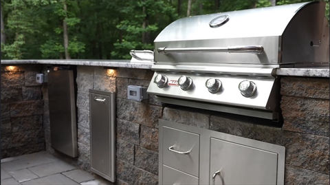 Stainless steel grill in a stone outdoor kitchenette