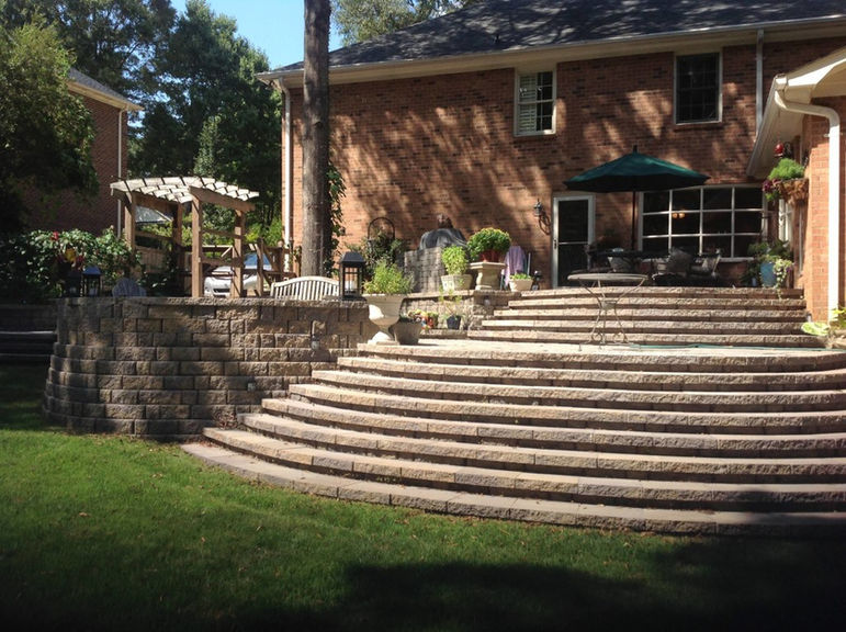 Curved stone stairway to heaven patio in a backyard.