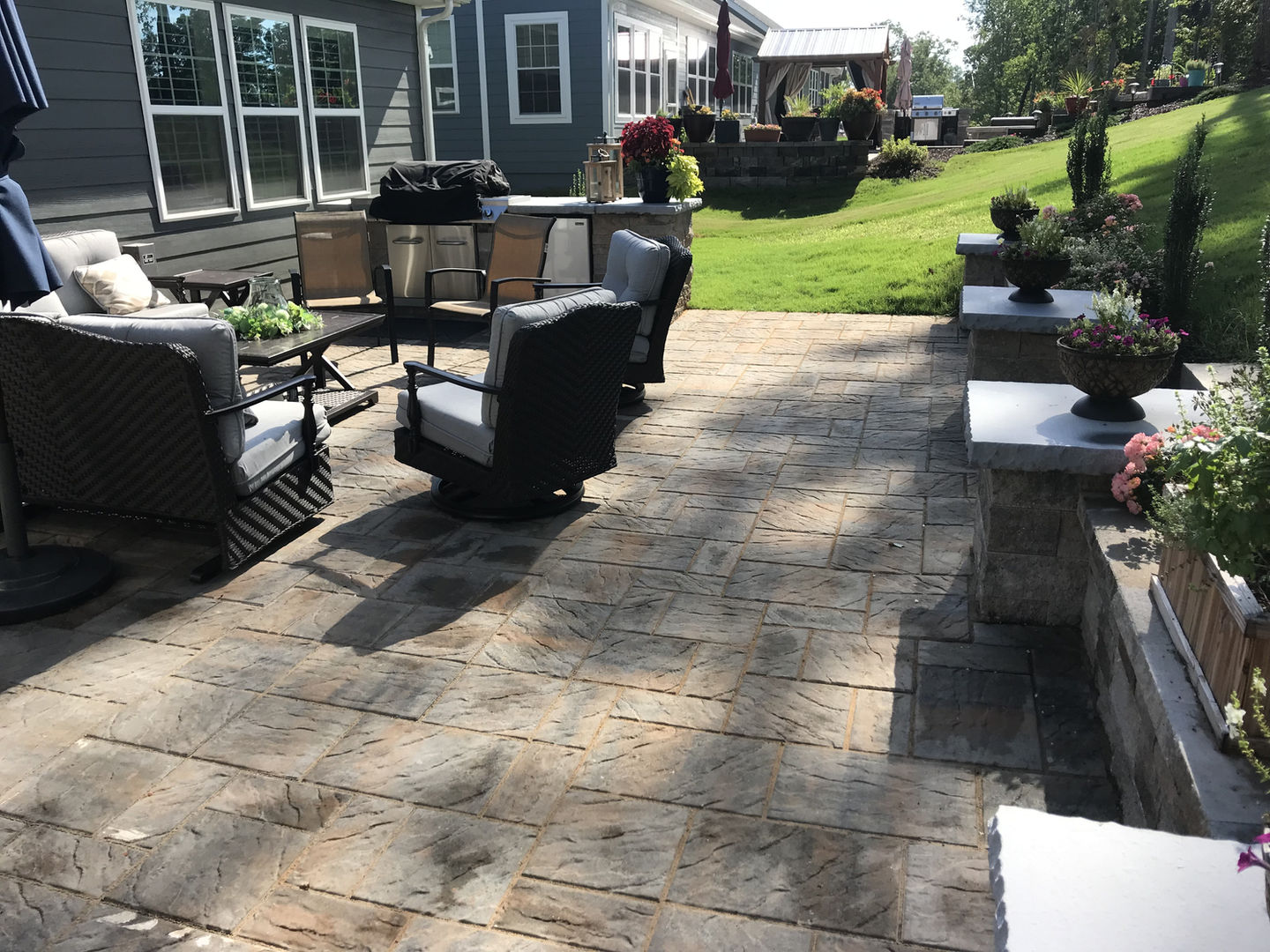Outdoor kitchen and stone patio with seating area.